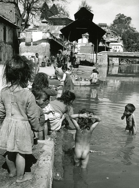 Barn badar i närheten av kremerings plattrormarna i Kathmandu Nepal