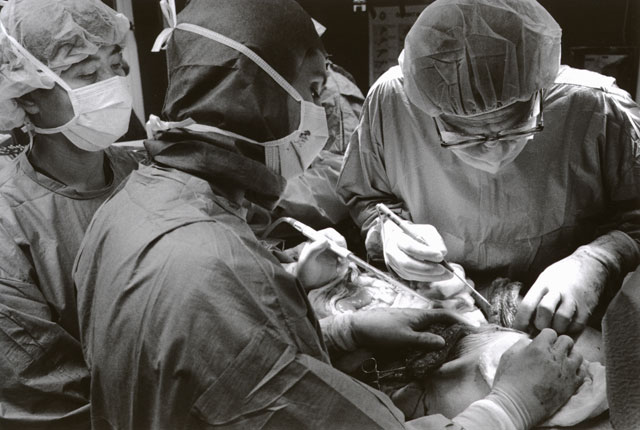 Tre kirurger vid kroppen