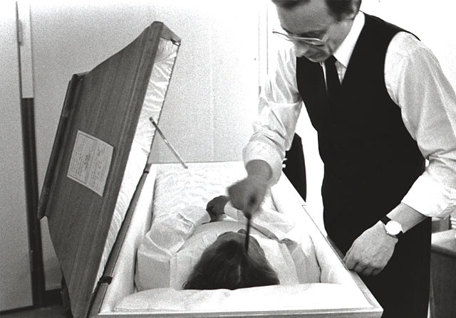 An undertaker combing the hair of the dead body
