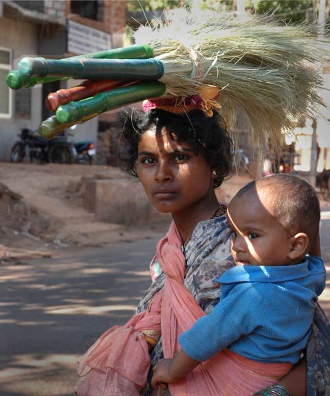 woman with child and brooms on her head