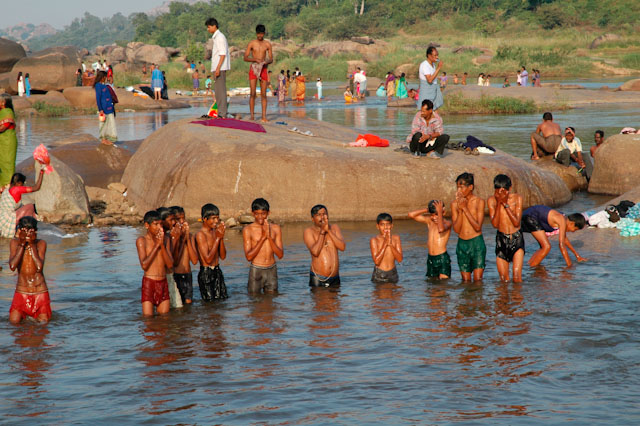 hampi boy pilgrims performing puja holy ceremony in the river