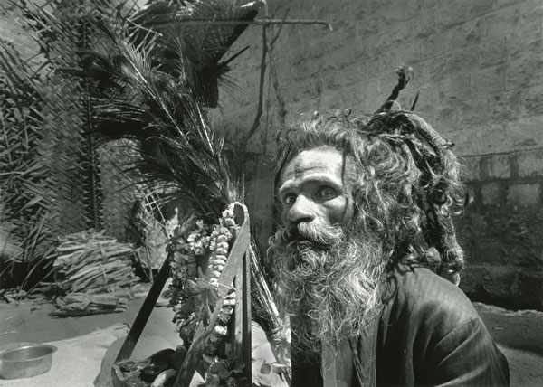 Sadhu with intense look wild hair due and peacock feathers
