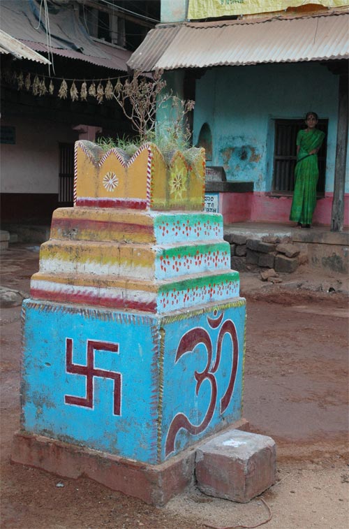The Swastika and Ohm symbols painted on a pedestal in front of a house