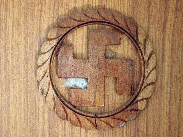 A wooden ornament in a hotel door with a swastika inside a cirkle