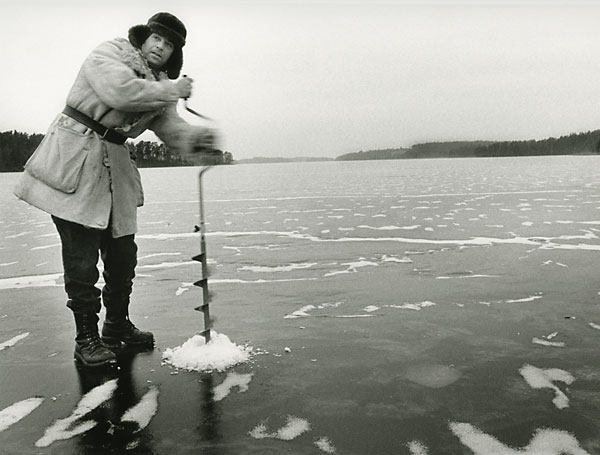 ice fishing drilling a holw in the ice