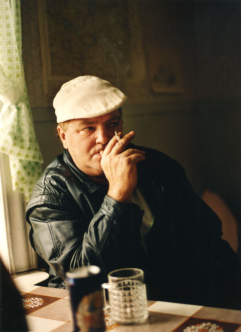 Man with cigarrette, beer and white hat, looking suspiciously