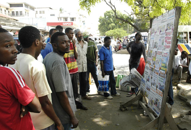 Men reading news at a news stand Stone town Zanzibar