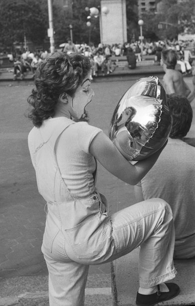 Mime in Washington square park. fixing her make up using the balloon as mirror