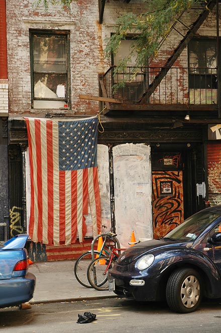 An old usa flag covering a window in an old building in Lower East side of Manhattan