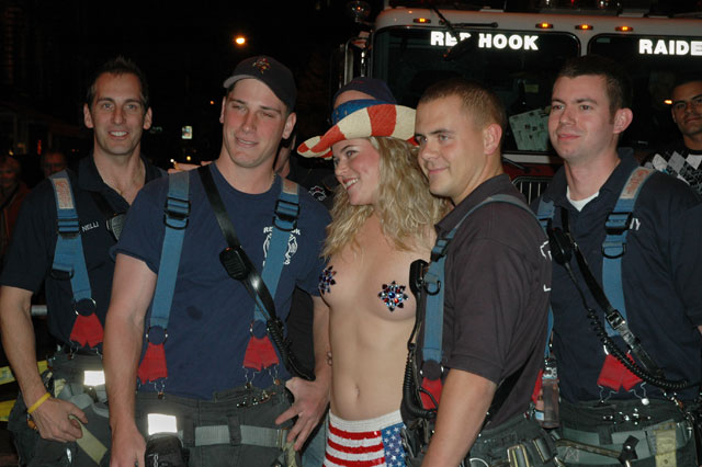 Halloween, Red hook riders. Blond woman with bare tits, american flag, stars and stripes, fire fighters posing with her.