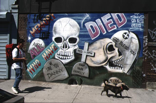 Mural on the Lower East Side depicting skulls and death. Volunteer and her dog from the Needle exchange program walking by