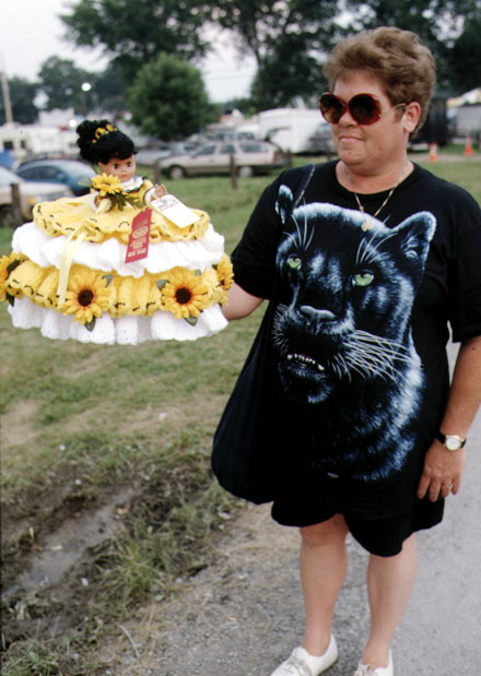 woman with huge panther design on T-shirt and yellow doll county fair