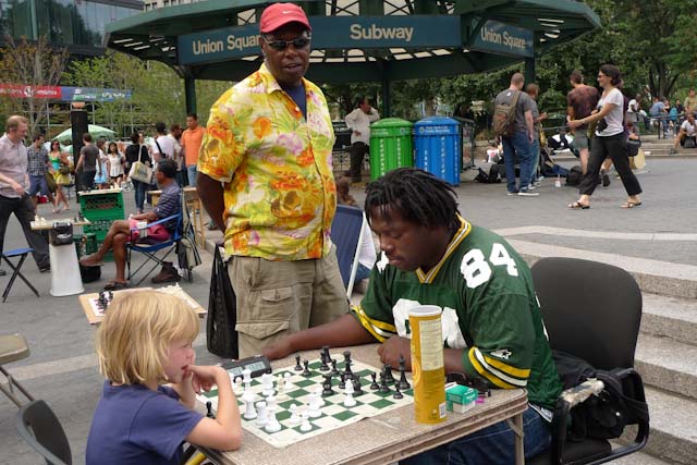 young boy playing chess with african american man union square new york near subway