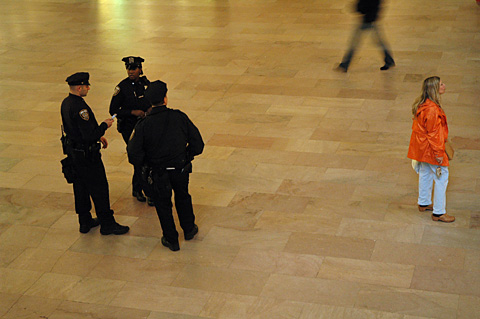 police at grand central woman in orange rain jacket