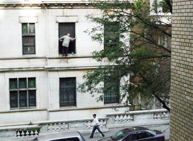 Man cleaning a window of a mansion at Riverside Drive and 107 Street, no safety equippment no rope no scaffold, nothing
