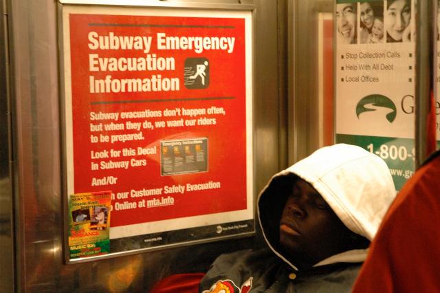 Subway Emergency Evacuation Information in New York subway. Man sleeping