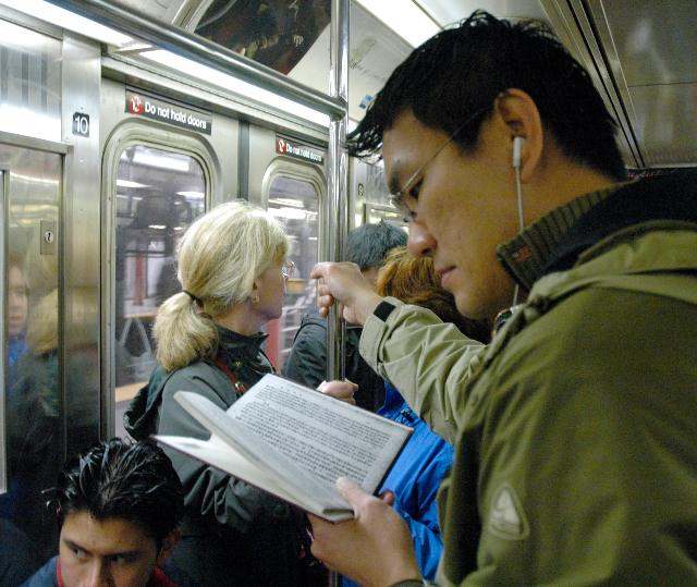 Man reading book in New York subway iPod